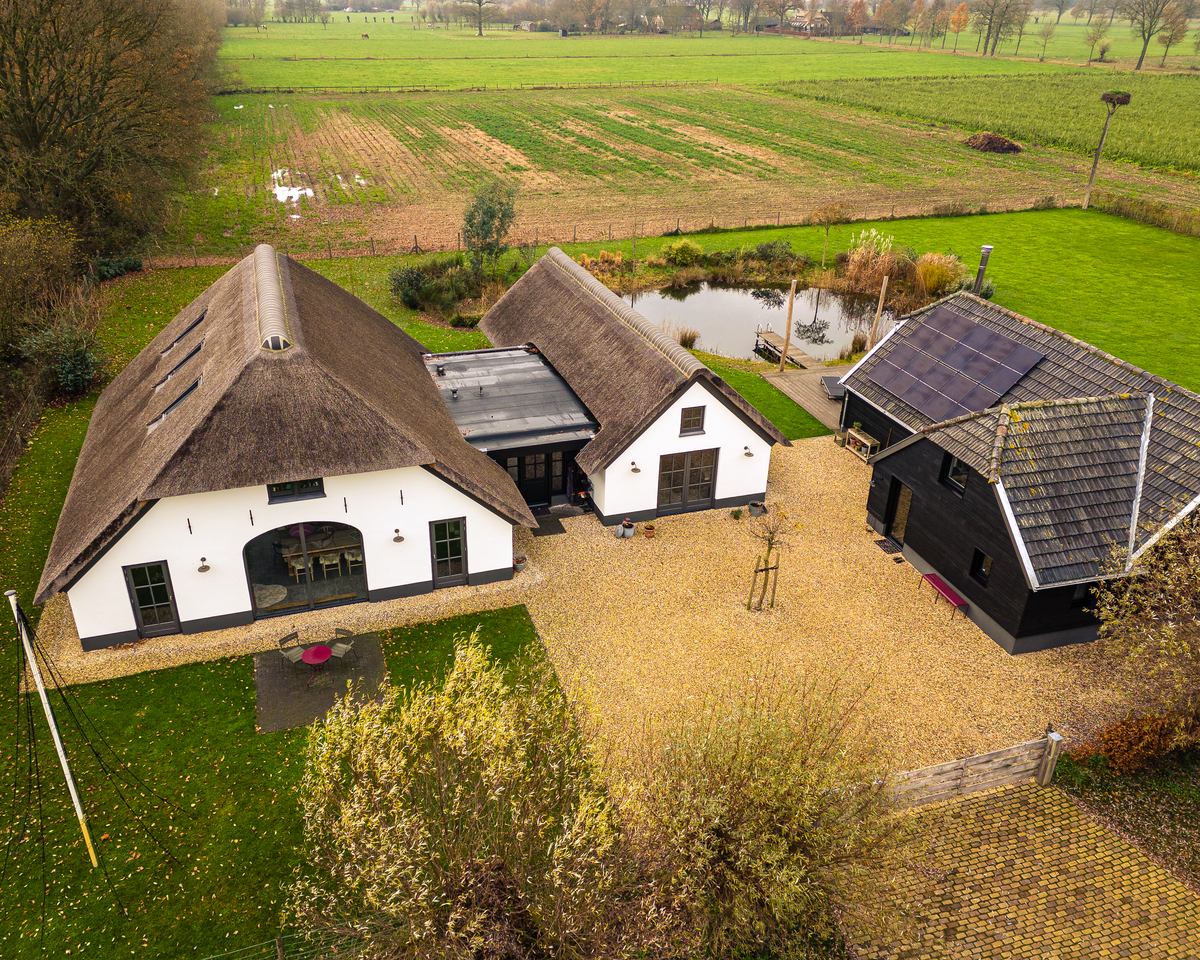 Karakteristieke witte boerderij met rieten kap, vakkundig gerenoveerd